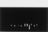 Ein weißer Karton steht senkrecht auf einem weißen Hintergrund. Durch die Veränderung der Beleuchtung erscheint die Projektion des in den Karton eingeschnittenen Schriftzugs des griechischen Wortes für weiß von Bild zu Bild immer deutlicher, um sich wieder aufzulösen. Bildreihe (2 von 4): Georgios Anastasiades